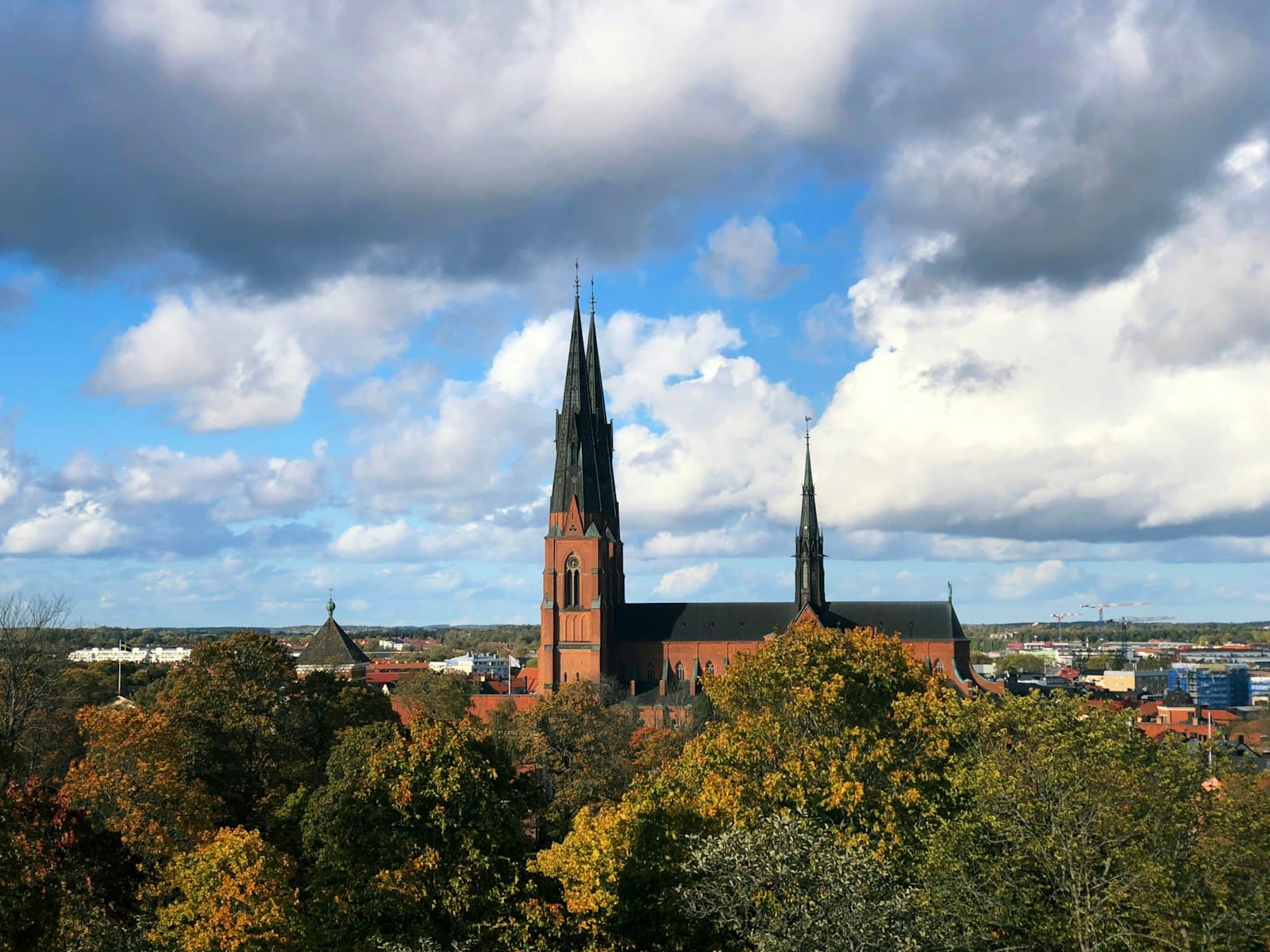 Uppsala — brown and black concrete building under white clouds and blue sky during daytime
