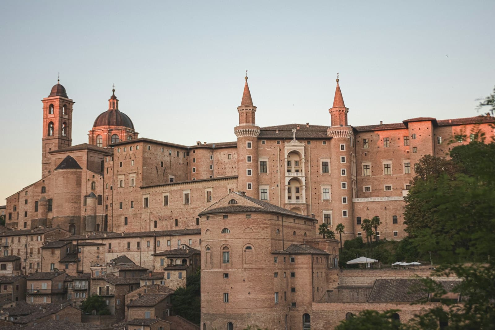 Urbino — a large building with a dome on top with Urbino in the background