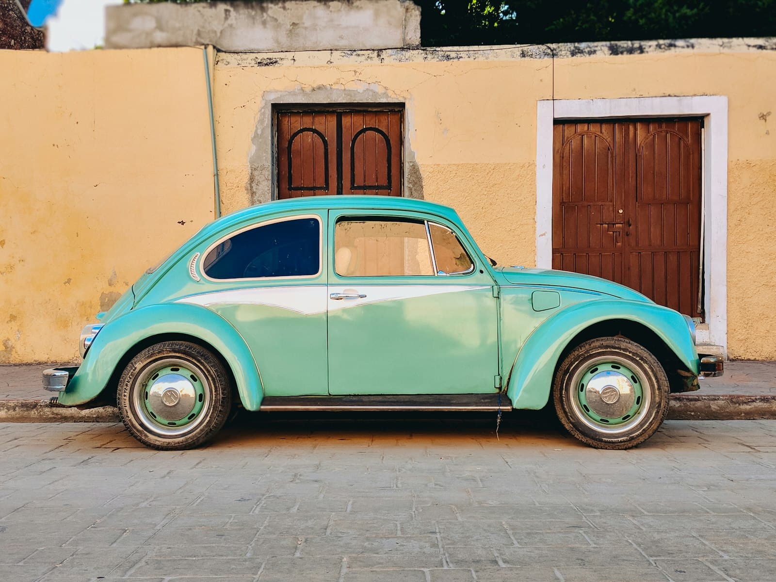 Valladolid — teal Volkswagen Beetle parked near brown house
