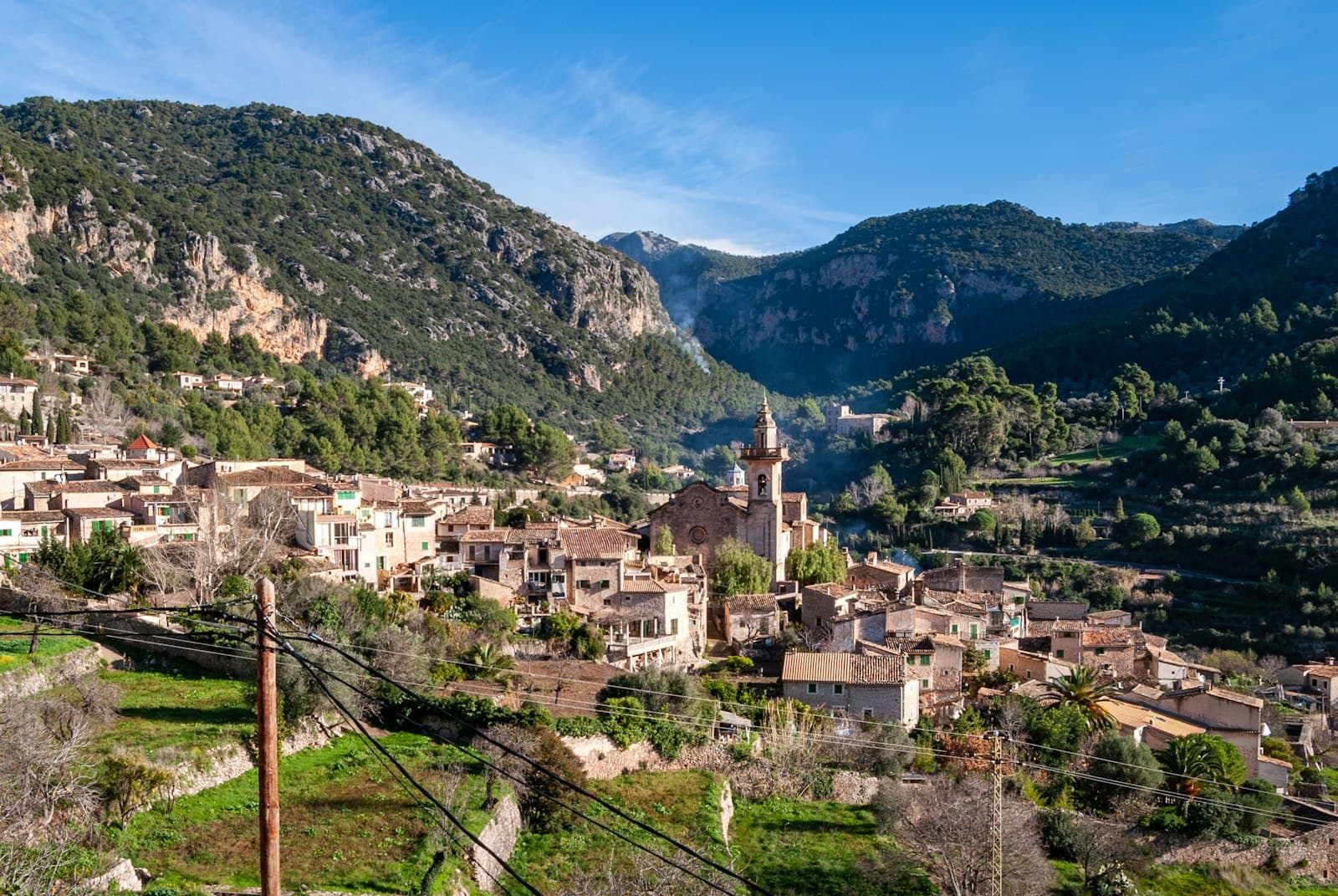 Valldemossa — white and brown concrete houses near green mountain under blue sky during daytime