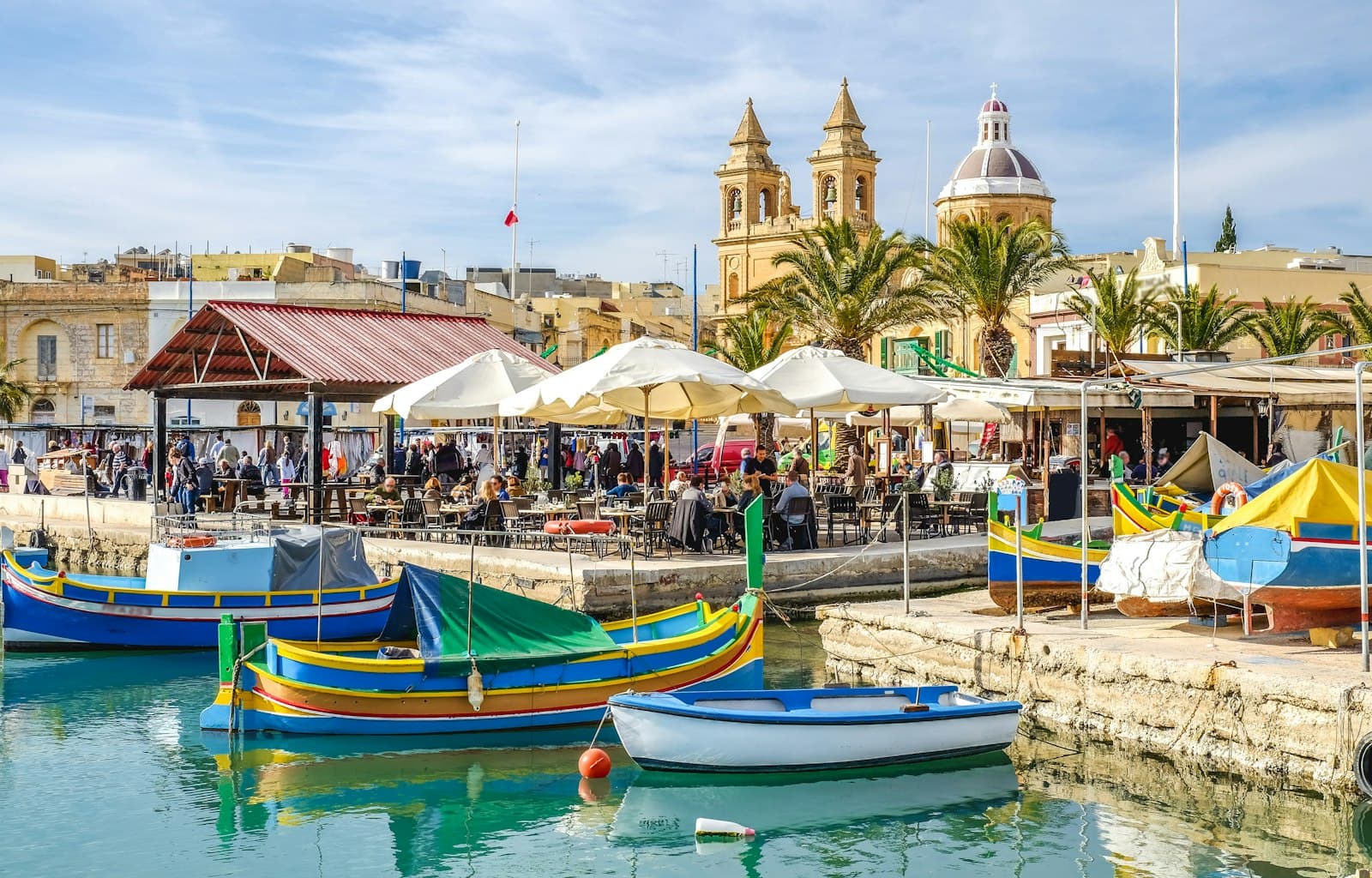 Valletta — blue and yellow boat on water near brown concrete building during daytime