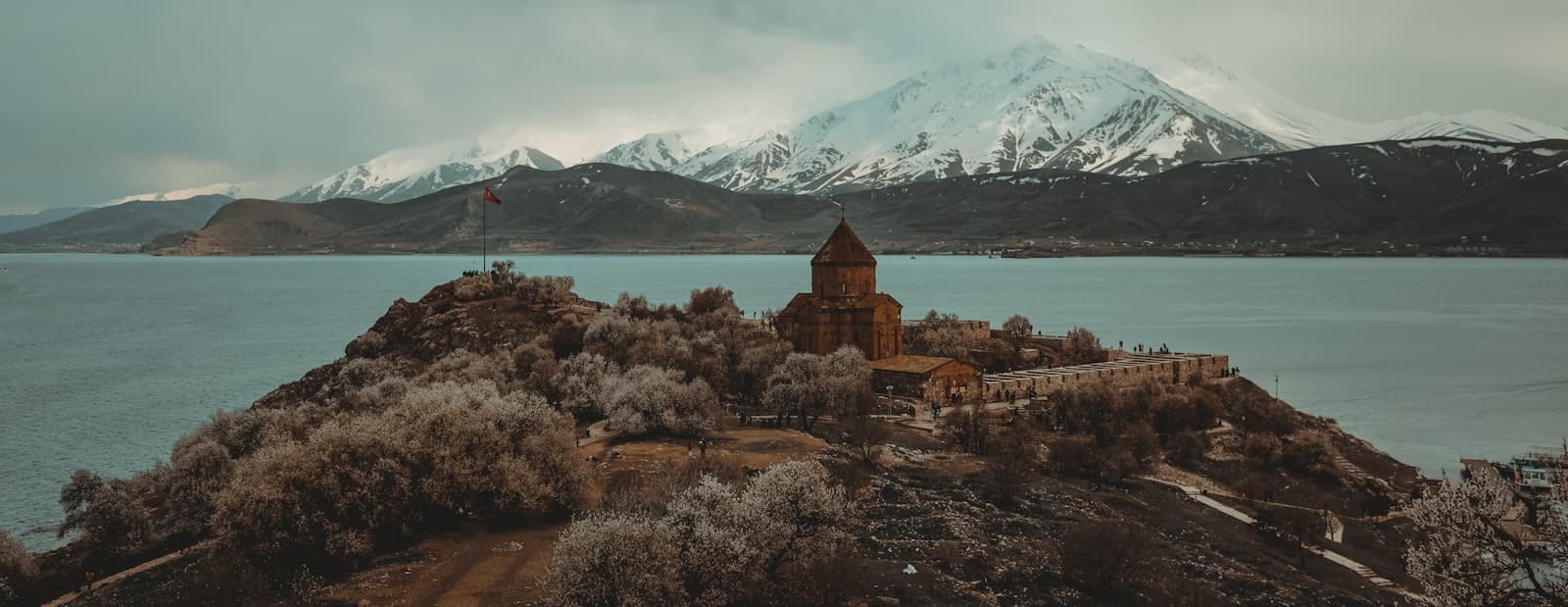 Van — brown concrete building near body of water during daytime