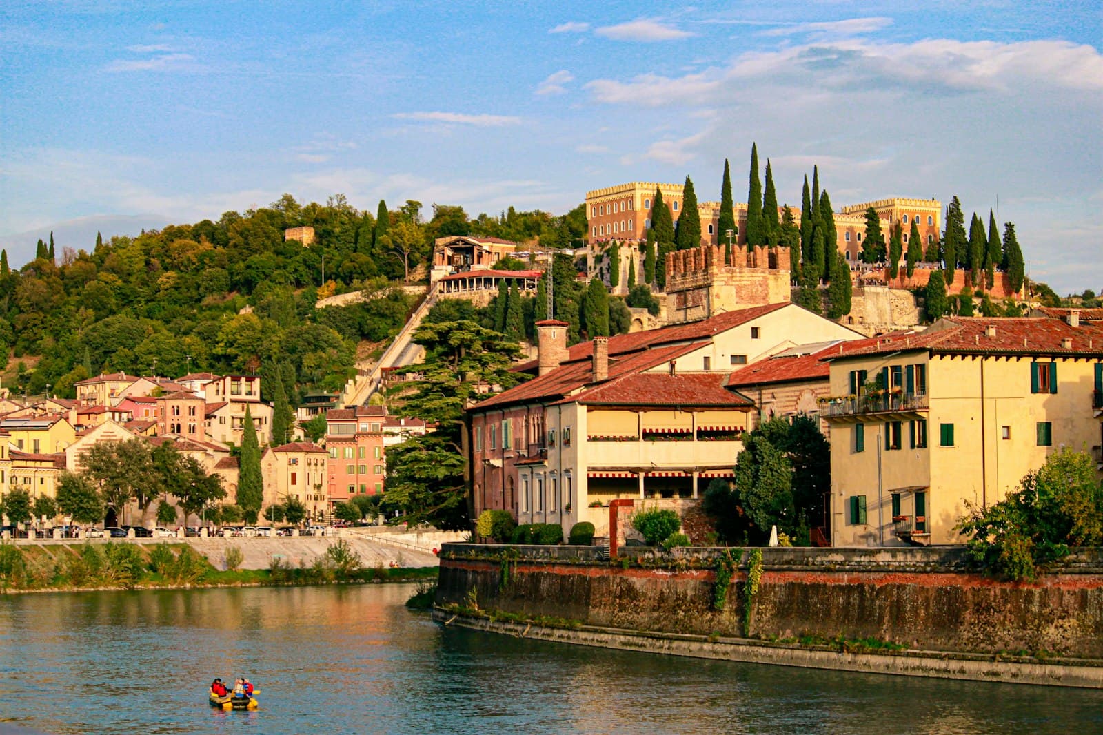 Verona — A river running through a small town next to a hillside
