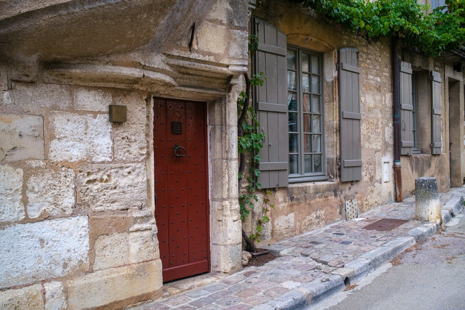 Vézelay — Old stone building with a red door and shutters