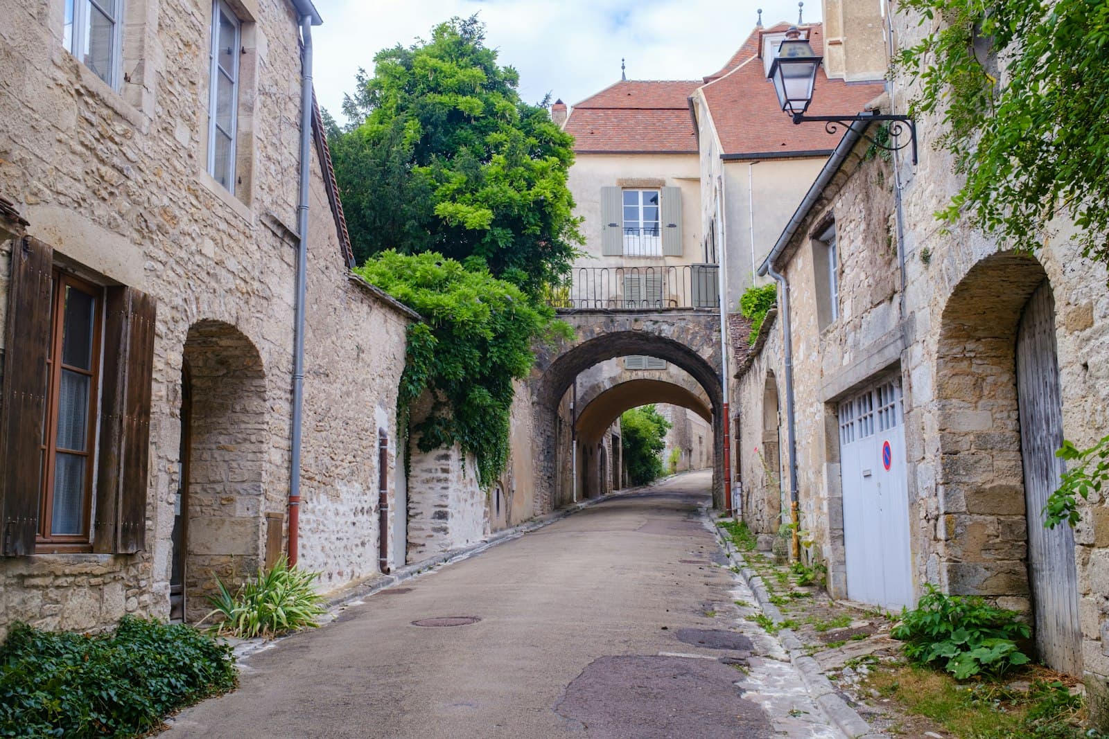 Vézelay — Narrow cobblestone street with stone buildings and arches