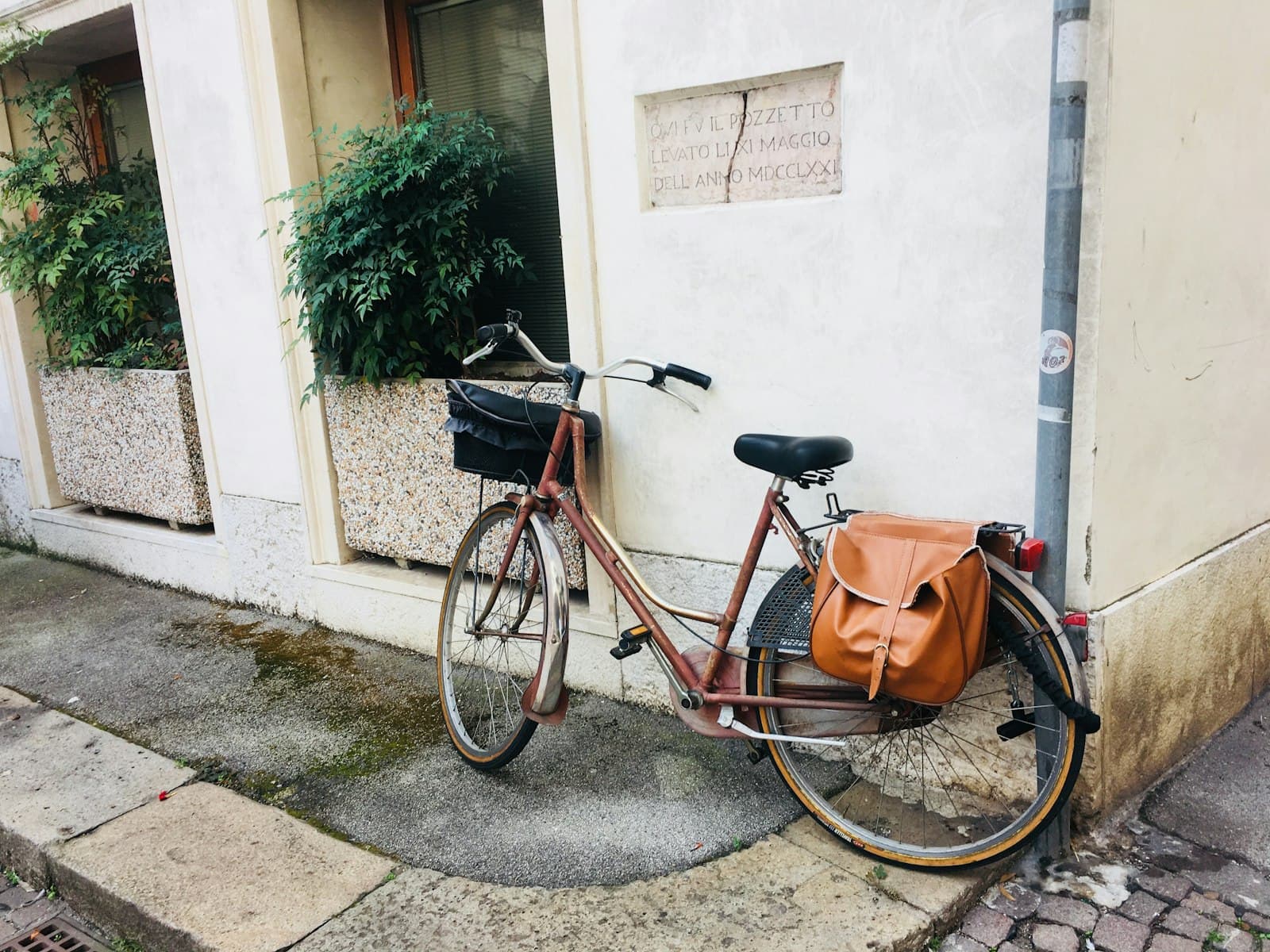 Vicenza — brown city bike parked beside white concrete wall