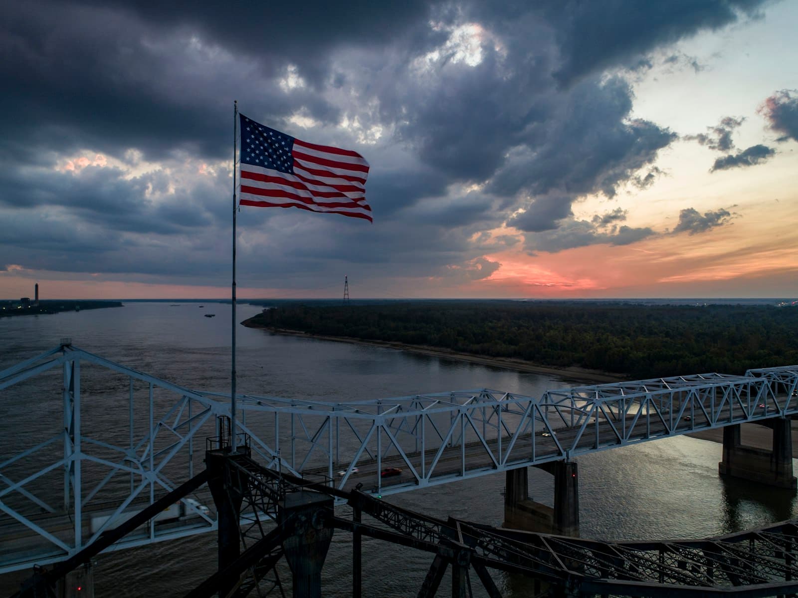 Vicksburg — an american flag flying on a bridge over a body of water