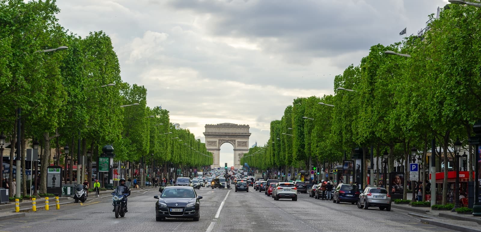 Villefranche-sur-Mer — a street lined with cars and motorcycles next to the eiffel tower