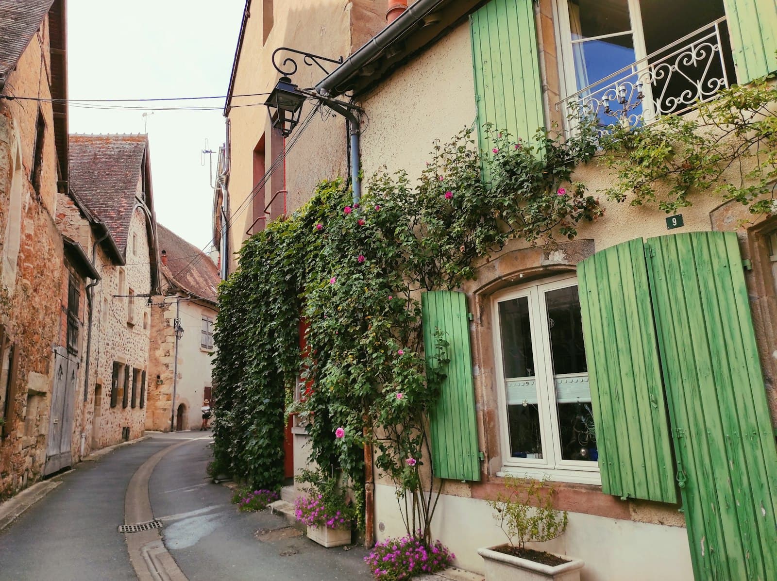 Villefranche-sur-Saône — a row of houses with green shutters and a green curtain