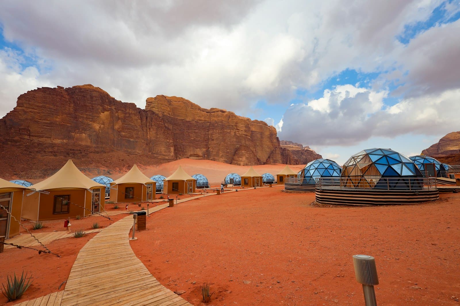 Wadi Rum — a group of tents in the desert with mountains in the background
