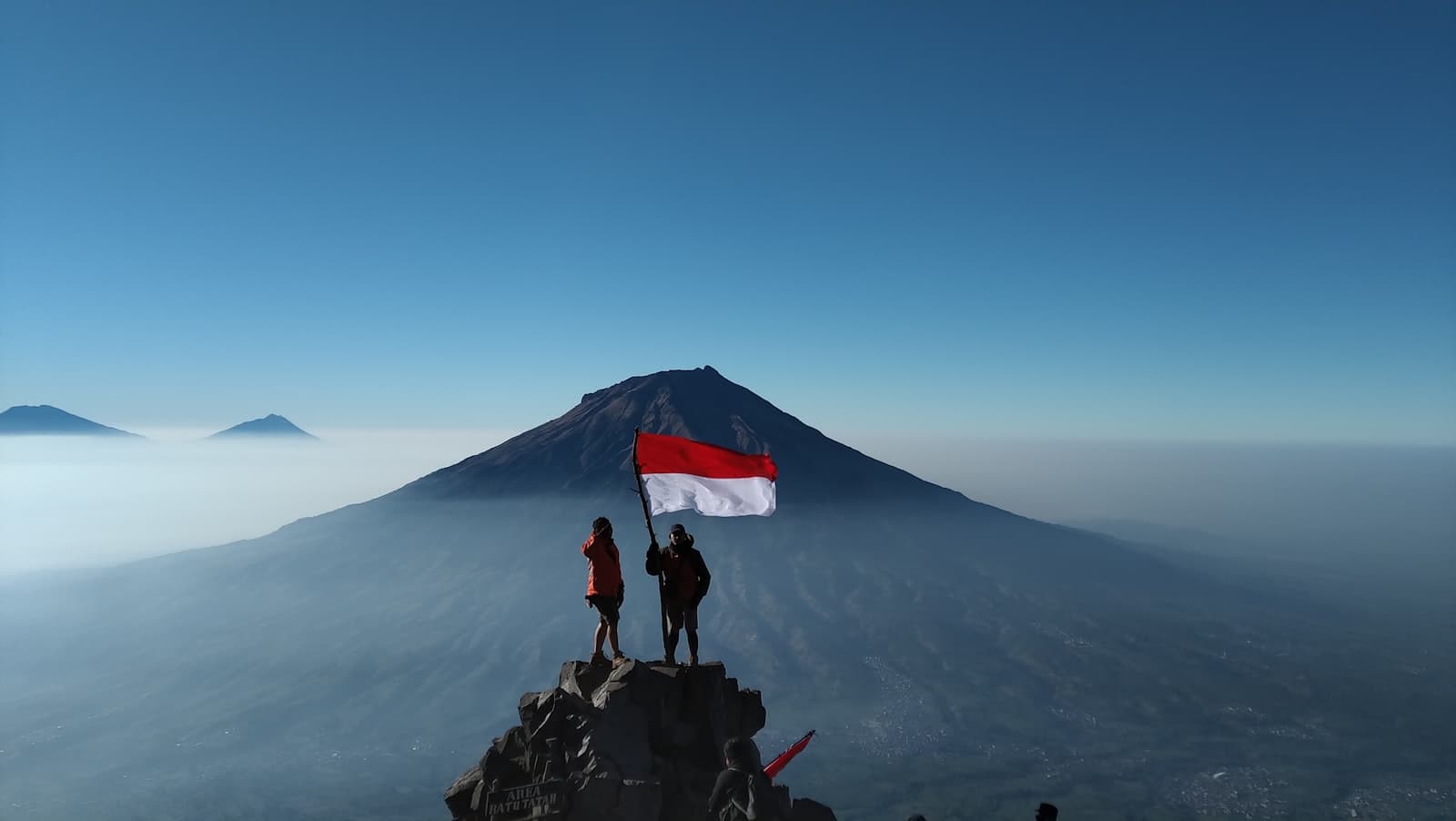 Waikabubak — person standing on rock near mountain under blue sky during daytime