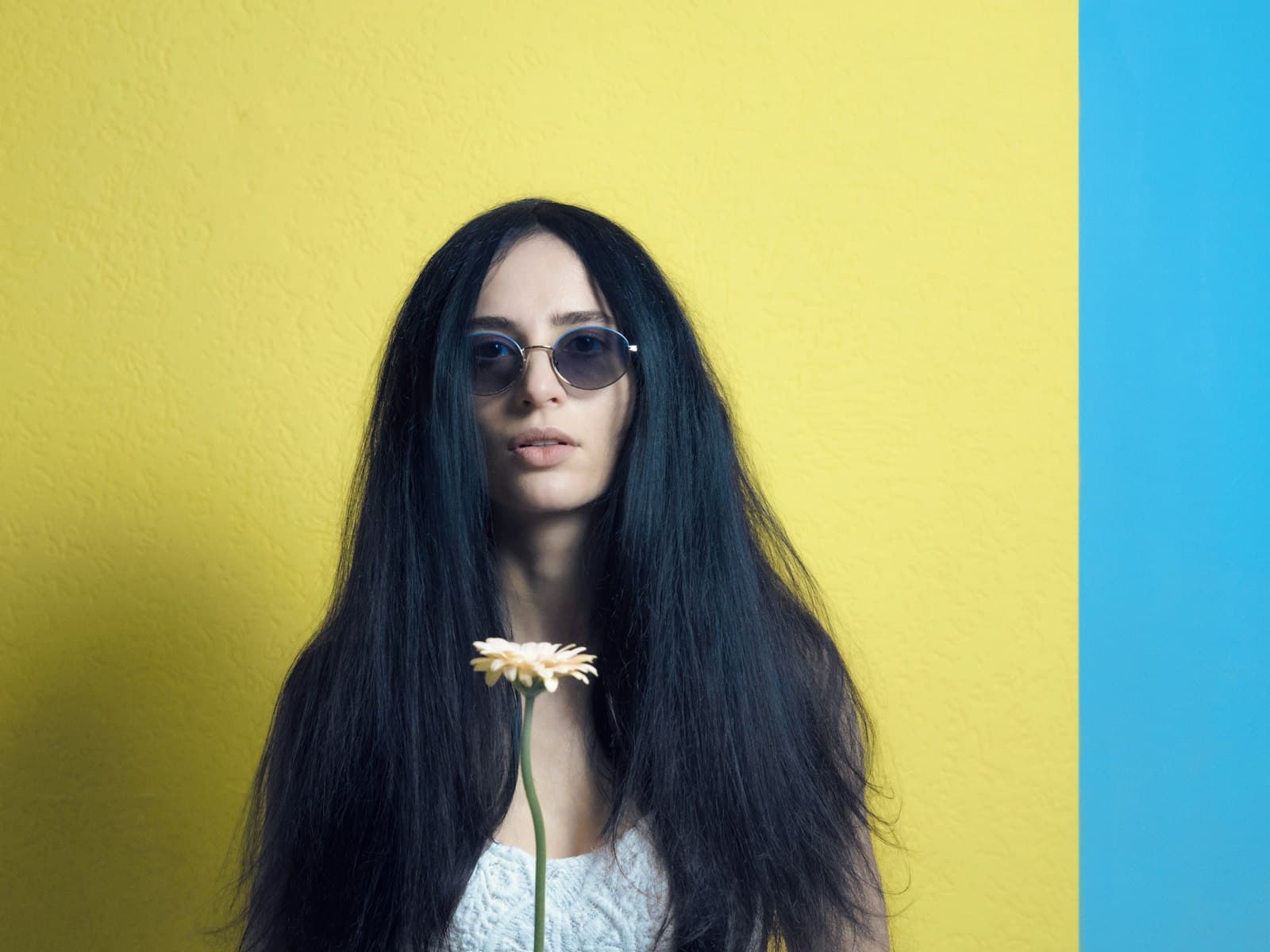 Weimar — a woman with long black hair and sunglasses holding a flower