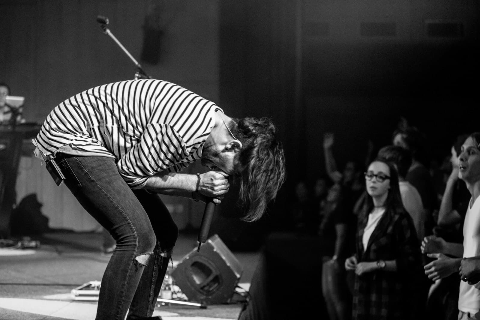 Wels — grayscale photography of people watching a man performing on stage