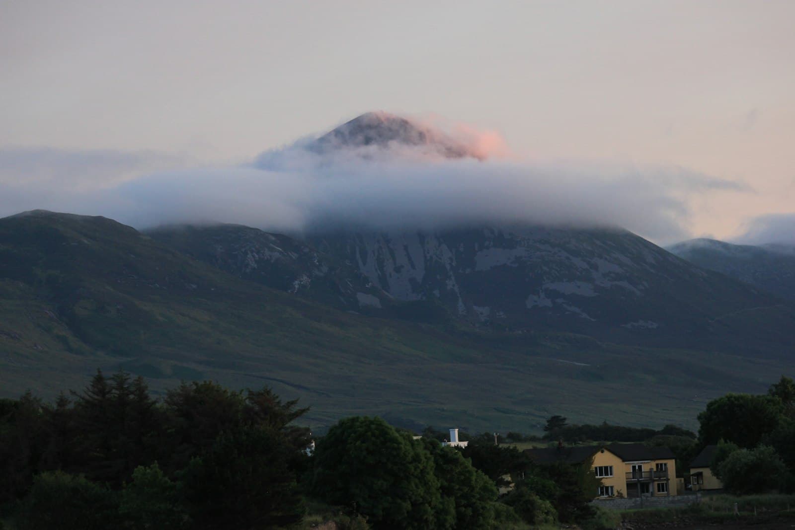Westport — a view of a mountain range with clouds and a house