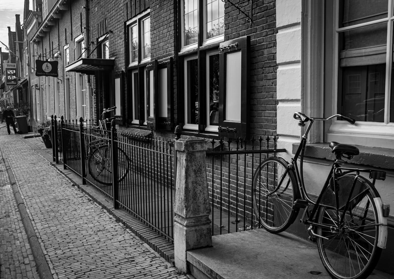 Willemstad — grayscale photo of bicycle parked beside building