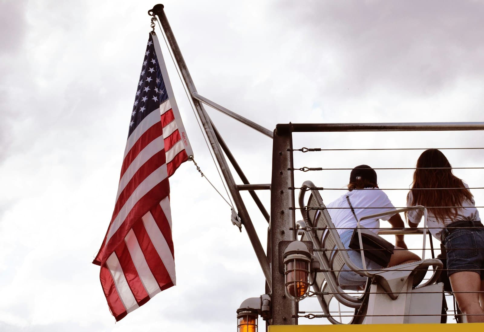 York — man in black jacket sitting on chair near us flag during daytime