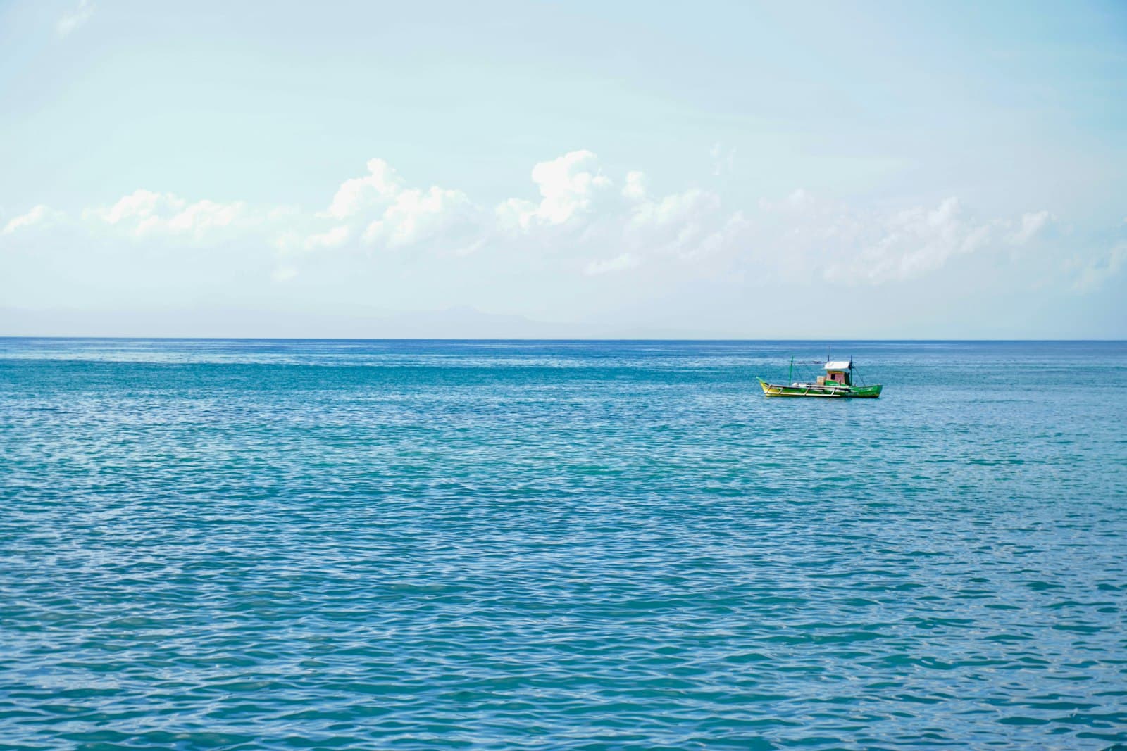 Zamboanga — a small boat floating on top of a large body of water