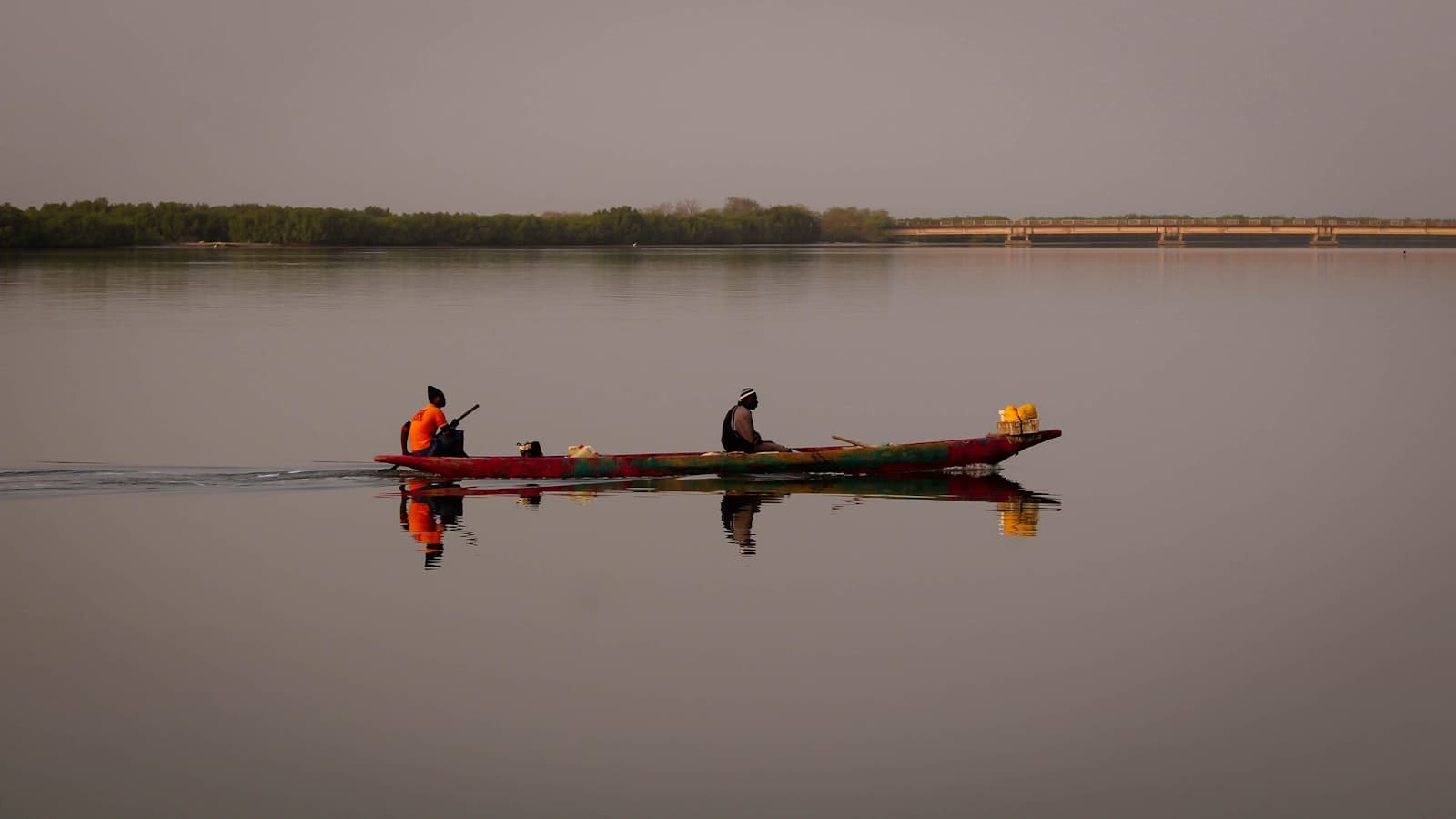 Ziguinchor — Two people in a long boat on calm water