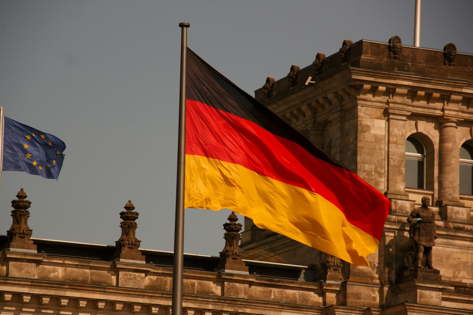 Zons — two flags flying next to each other in front of a building